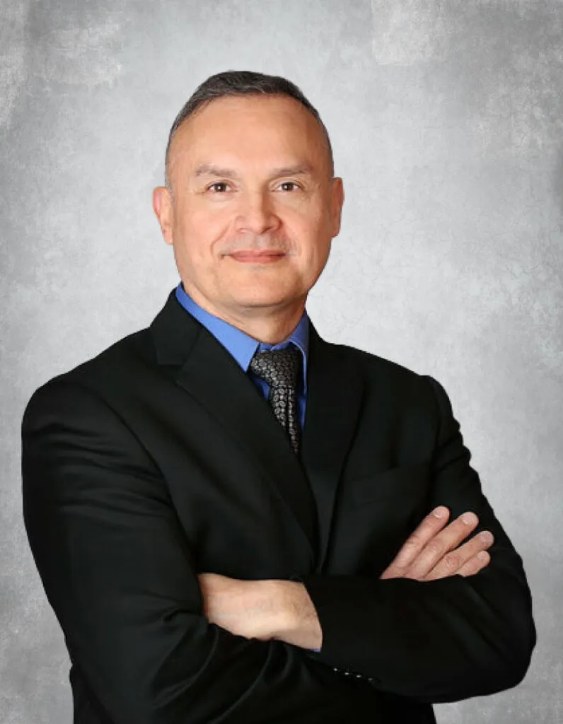 Portrait of male dentist in professional attire with arms crossed