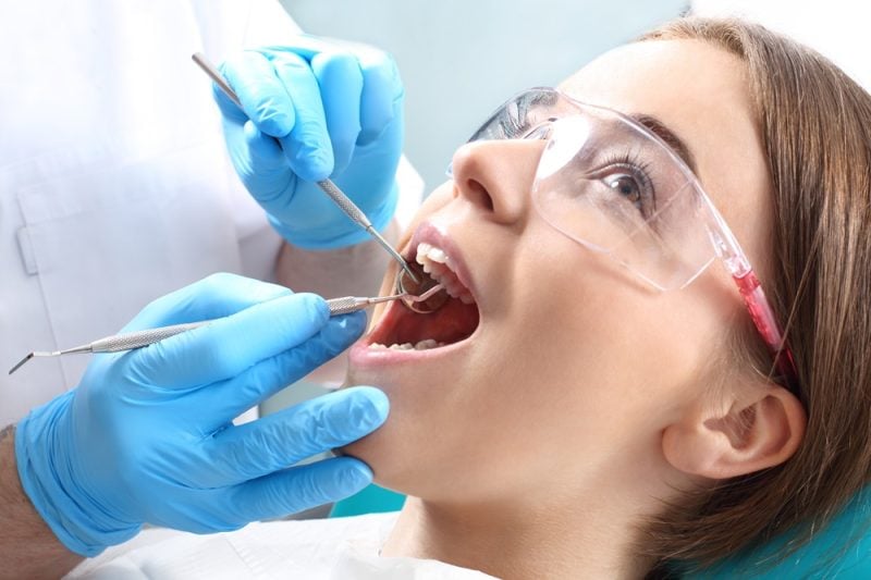 Patient receiving dental checkup and professional teeth cleaning